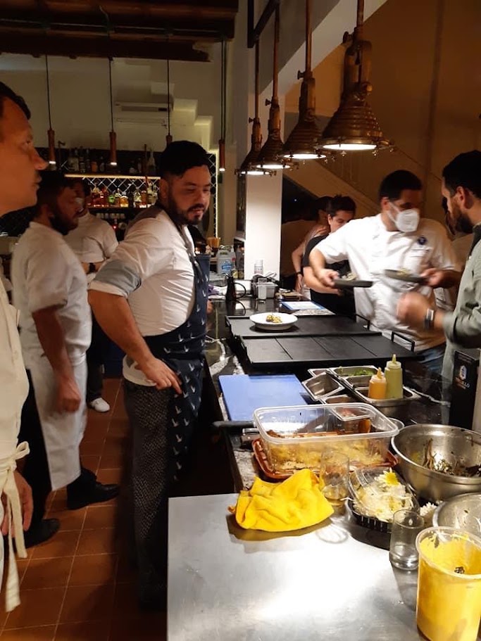 Chef Franko carefully plating a dish in a professional kitchen
