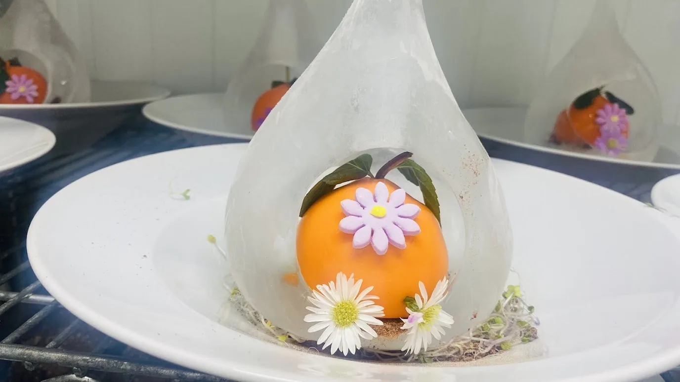 Artistic dessert presented inside a blown sugar sphere
