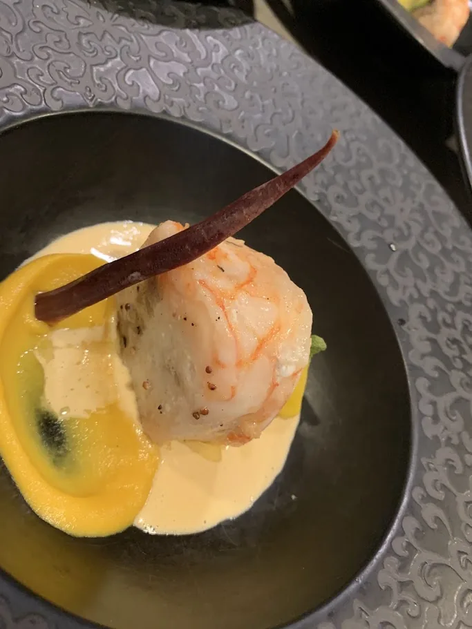 Seared seafood plated with citrus puree, vanilla and a delicate sauce